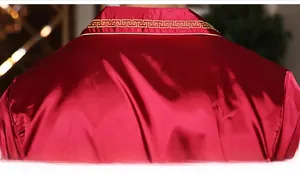 Detailed close-up of golden geometric embroidery on red satin silk pajama collar