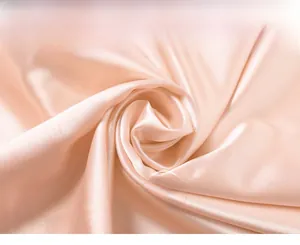 Macro detail of soft pink silk fabric showing smooth texture and glossy draping
