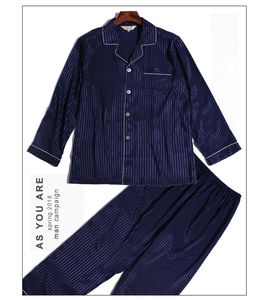 Close-up of navy blue striped silk-like pajama set with white piping on the lapel