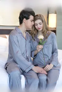 Close-up of silvery satin pajamas with red piping and classic vertical stripes