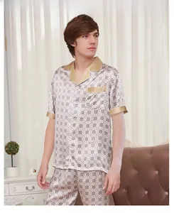 Detail of men's silk pajama set showing luxury printed fabric and champagne gold piping