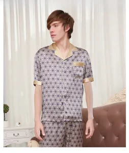 Detail view of men's silk pajama set featuring blue geometric patterns and gold piping