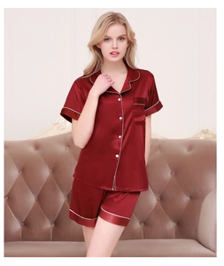 Detail of wine red satin pajama set with white piping and button-down short sleeve top