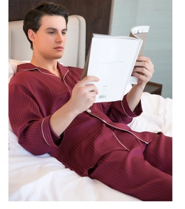 Detail of burgundy striped satin pajamas for men with white piping and button closure