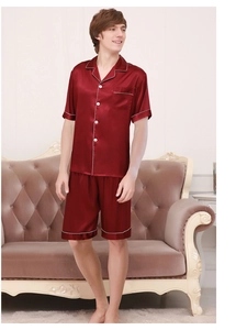 Mens burgundy satin short sleeve pajama set with white piping on sofa background