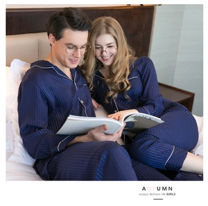Detail of silk-like navy blue striped pajamas with classic white contrast piping