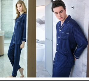 Detail of silk-like satin pajamas with vertical stripes and white contrast piping