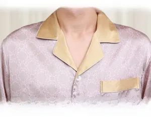 Detail of men's silk pajama top with chain print and contrast satin lapels