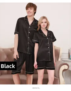 Detail of silk satin couple pajamas in black with elegant white piping and luxury texture