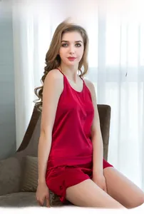 Detailed view of red silk satin pajama set with camisole and shorts featuring bow accents