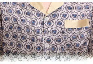 Detail of silk pajama top with geometric print, V-neck collar and chest pocket trim