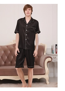 Detail of men's black satin pajama set with contrast piping and silk-like sheen finish