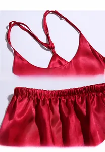 Detail view of red silk pajama set with adjustable straps and elastic waistband texture