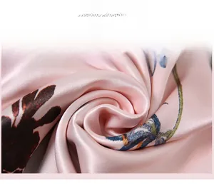 Gros plan sur le tissu en soie rose fleuri du pyjama montrant sa texture lisse