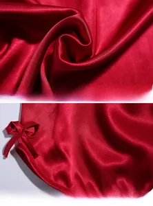 Detail of red silk sleepwear fabric texture and curved hem with a matching bow decoration