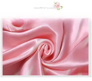 Détail de la texture fluide et soyeuse du tissu à rayures roses et blanches au fini brillant