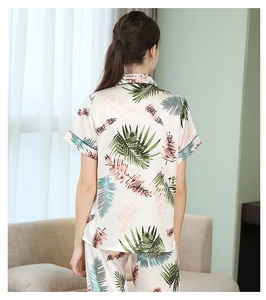 Détail d'un pyjama en satin avec imprimé de feuilles tropicales et texture soyeuse