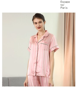 Détail d'un pyjama en satin à rayures roses et blanches avec liseré noir et poche