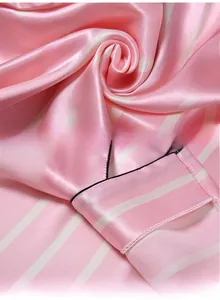 Vue détaillée de la texture du pyjama en soie à rayures roses et finition de l'ourlet
