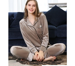 Détail d'un pyjama en velours doré luxueux avec bordure noire et col de chemise boutonné