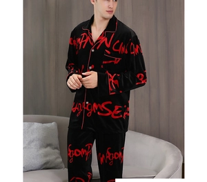 Detail of men's black velvet pajamas featuring red graffiti print and contrast piping