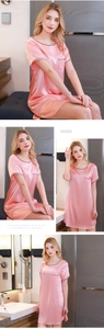 Dettaglio di camicia da notte in raso rosa con maniche corte, bordini neri e taschino sul petto