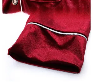 Macro shot of burgundy velvet pajama detail with white piping and textured button
