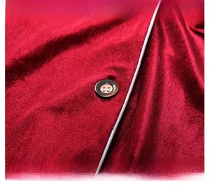 Close-up of red velvet pajama with white piping trim and detailed resin buttons