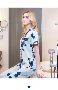 Detail of floral printed silk-like pajamas with contrast piping in a bathroom setting