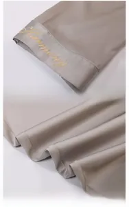Detail of gold Harmony embroidery on premium silk-like satin loungewear fabric