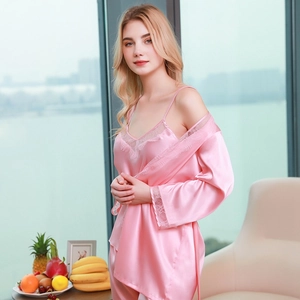 Pink silk satin three-piece pajama set with lace trim shown on a model at home