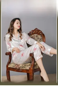 Detail of silk-like floral pajama set featuring pink flowers on creamy white fabric