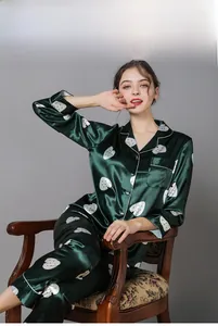 Detail of dark green satin pajama set with white heart prints and contrast piping