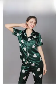 Detail of green silk pajama set with white strawberry prints and button-down collar