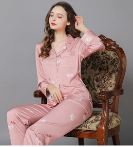Detail of pink silk pajama set featuring horse print and white piping on the lapel