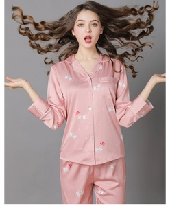 Close-up of pink silk pajamas featuring white pegasus prints and decorative lettering