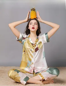 Close-up of women's silk pajamas featuring yellow floral print and light blue buttons