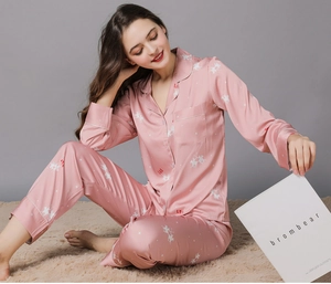 Detail of pink silk pajamas featuring white pegasus print and soft satin texture fabric