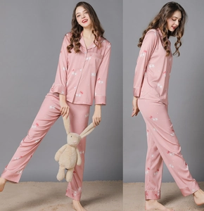 Detail of pink silk pajama set featuring white horse prints and LOVE lettering