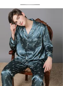 Detail of men's dark green satin pajama set with white bird print and button-up front