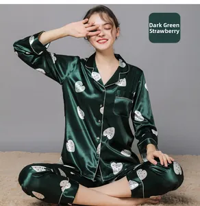 Detail of dark green silk satin pajamas with white strawberry print and contrast piping