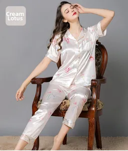 Detail of silk pajamas featuring pink lotus print and delicate contrast piping on the collar