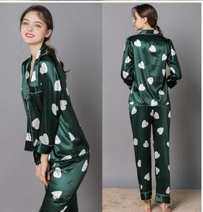 Detail view of dark green satin pajama set with heart print and contrast piping