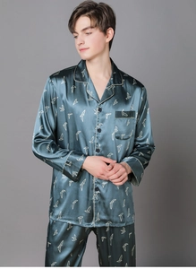 Detail of silk-like men's pajama set in dark green with white piping and bird print
