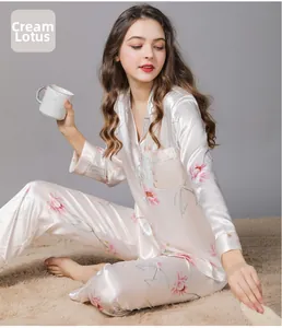 Detail of silk satin pajama set in creamy white featuring pink lotus flower prints