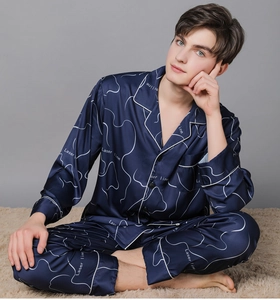 Detail of navy blue silk pajama set with geometric print and white piped edges