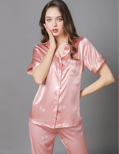 Detail of pink satin short-sleeved pajama set with white polo horse and SW1 prints