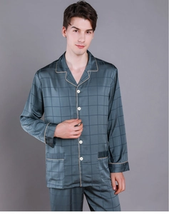Close-up of silk pajamas showing contrast piping and plaid pattern on dark grey satin fabric