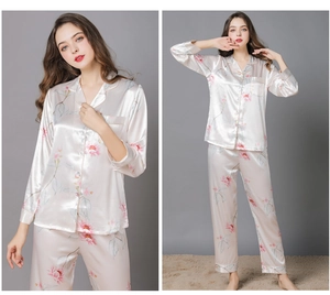 Detail of silk-like pink floral pajama set with long sleeves and button-down front