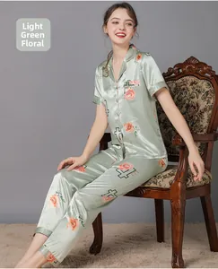 Detail view of light green silk pajamas with pink floral and number print on soft fabric